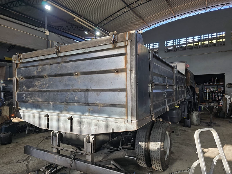 Caçamba agrícola em fabricação, ainda sem pintura, vista de trás em três quartos