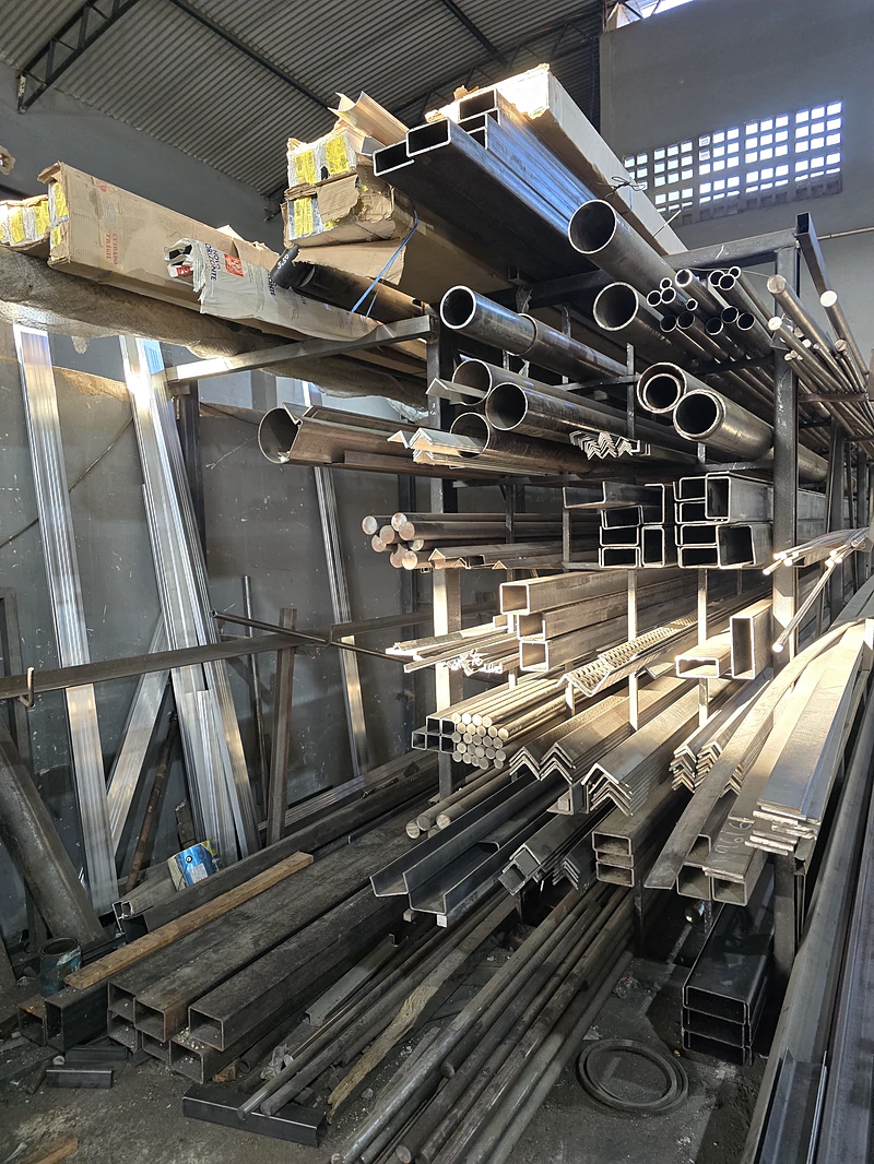 Rack com perfis, tubos e barras de aço no galpão da JC
