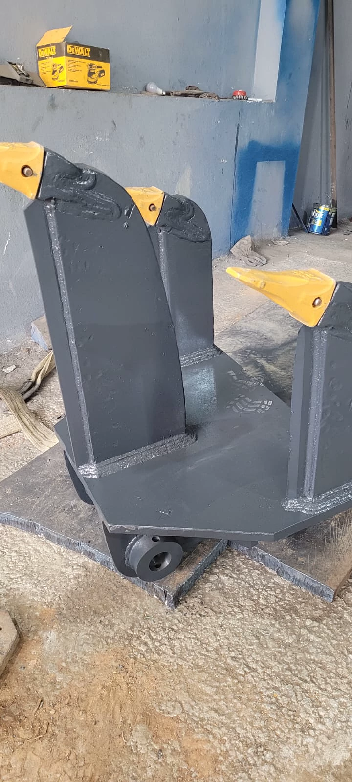 Sucador para escavadeira fabricado pela JC, pintado de cinza, com as três unhas amarelas no lugar